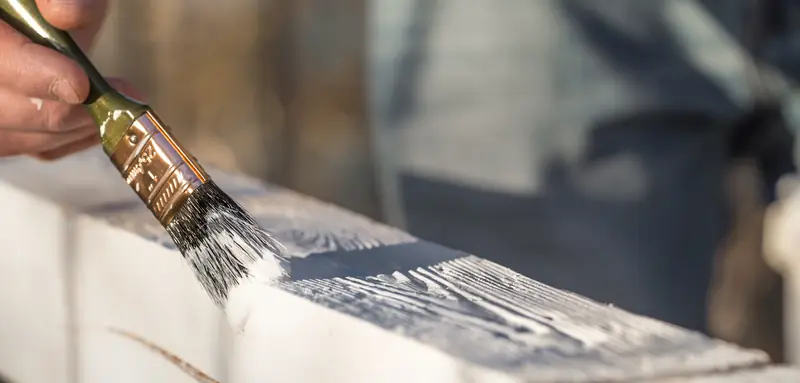 Peinture de boiseries — application au pinceau de peinture blanche sur bois