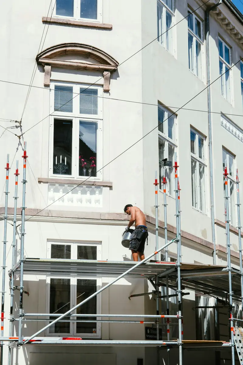 Ravalement de façade immeuble haussmannien — artisan en hauteur sur échafaudage