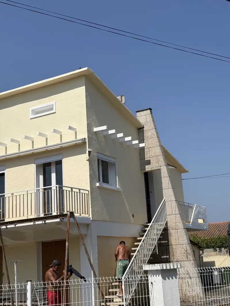 Façade de maison en cours de finition à Béziers — peintres sur échafaudage devant l'enduit jaune