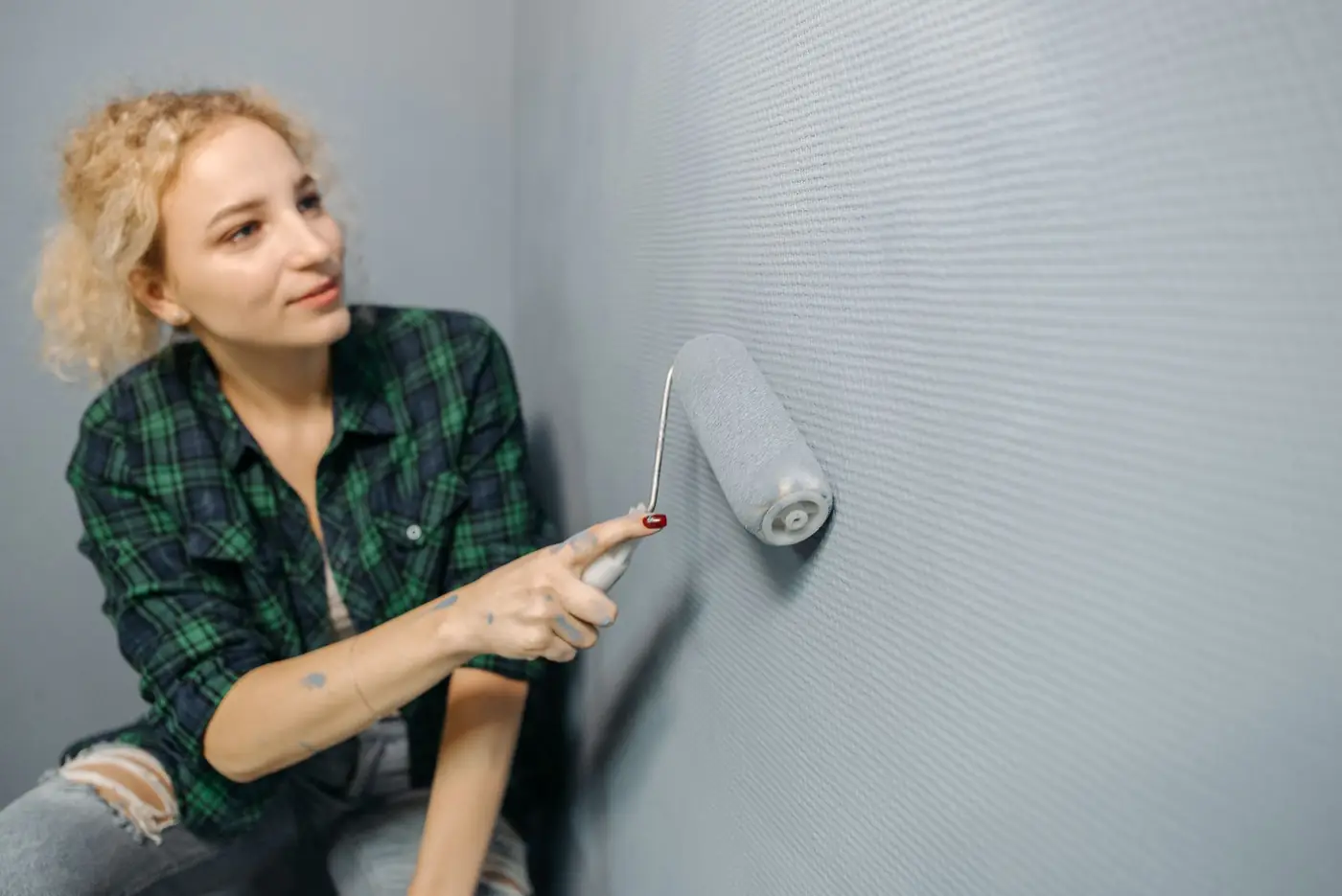 Application de peinture au rouleau sur un mur intérieur à Béziers